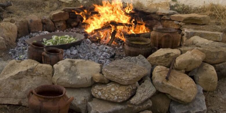 Traditional Minoan food cooking setup with clay pots over an open fire in Crete.