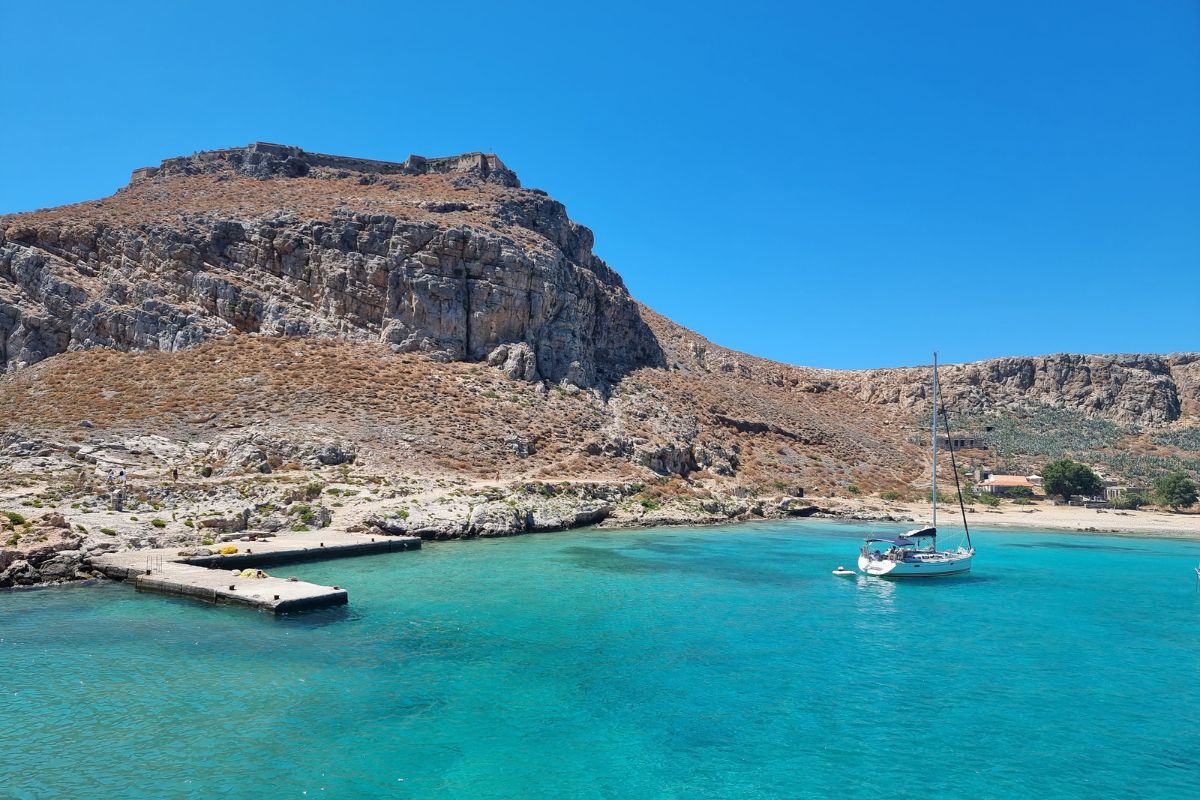 Clear turquoise waters and rocky coastline near Plaka village in Crete, Greece – sailing destination and summer travel spot