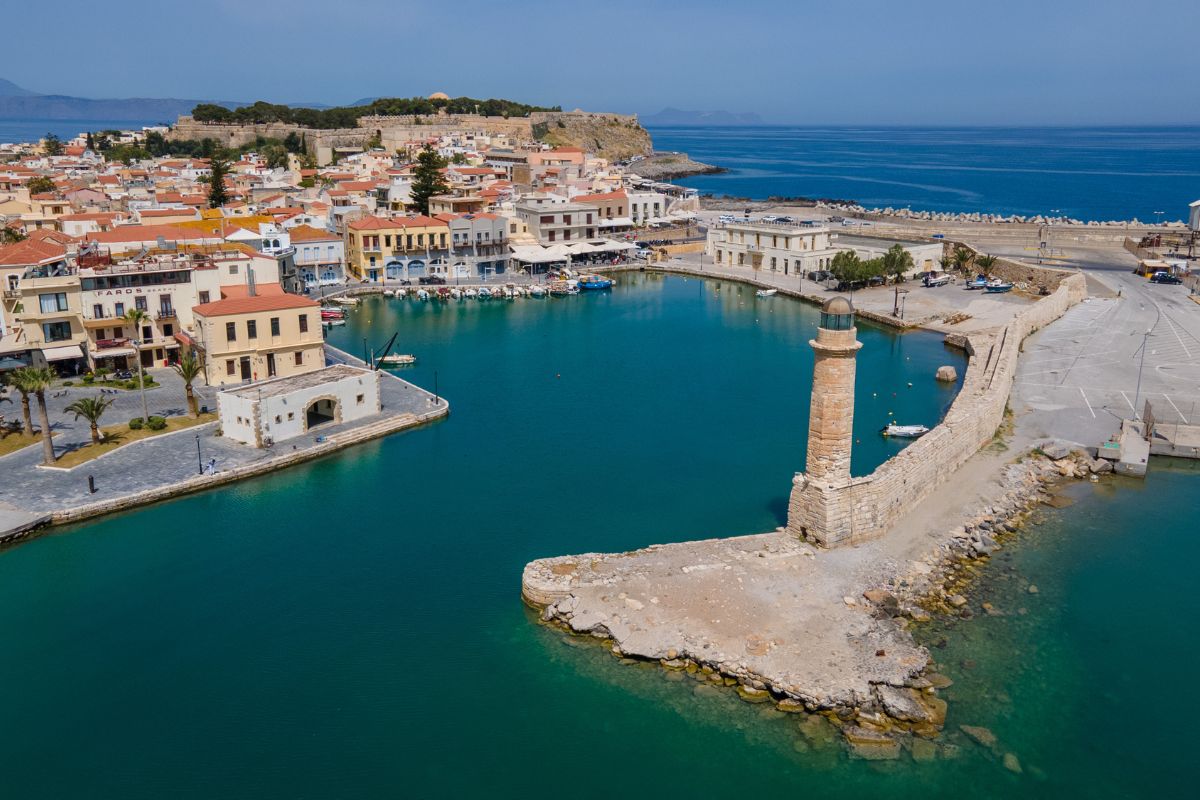 Aerial view of Rethymno Old Town and Venetian harbor with lighthouse in Crete.