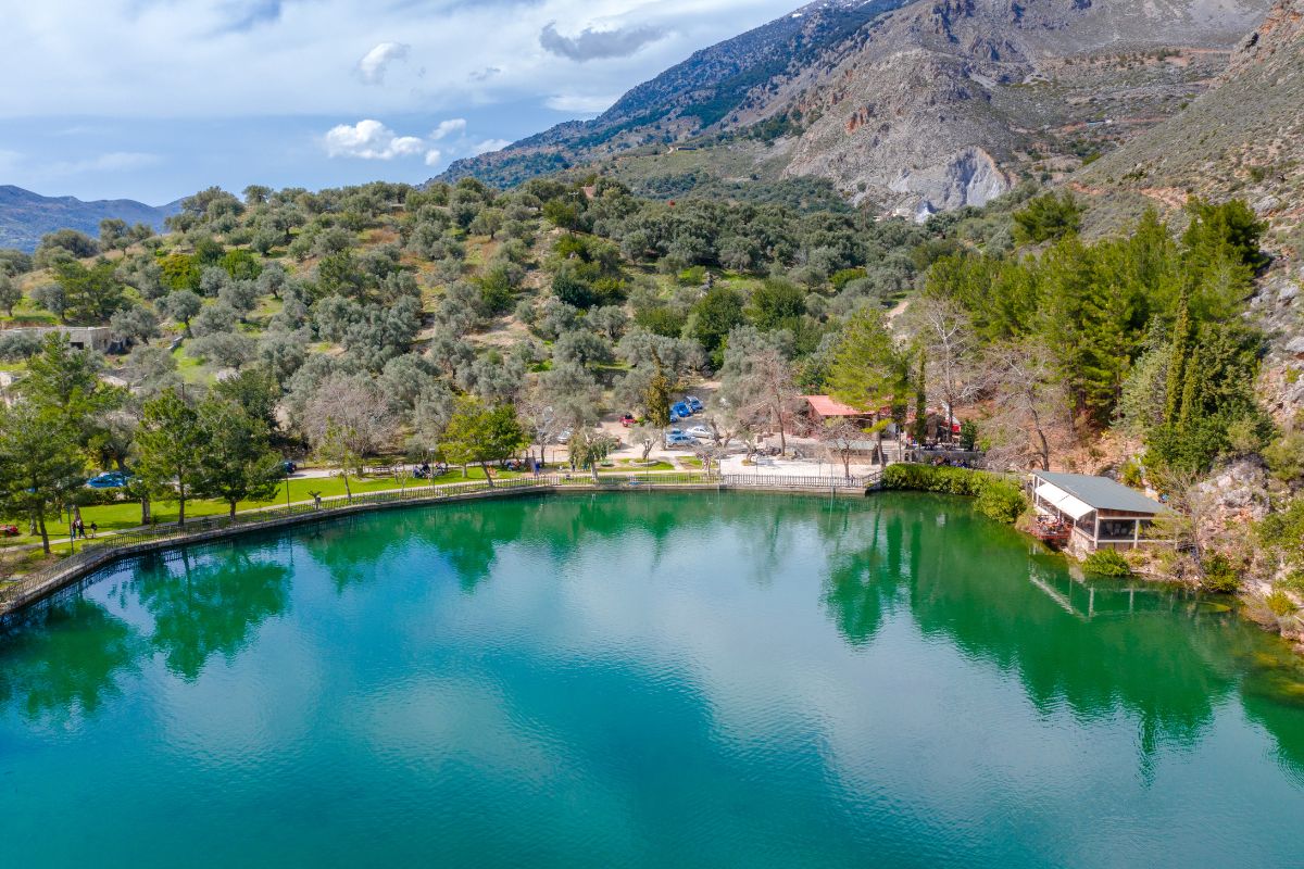 Zaros Lake in central Crete, a tranquil mountain lake surrounded by greenery and a popular starting point for nearby Crete gorges hikes.