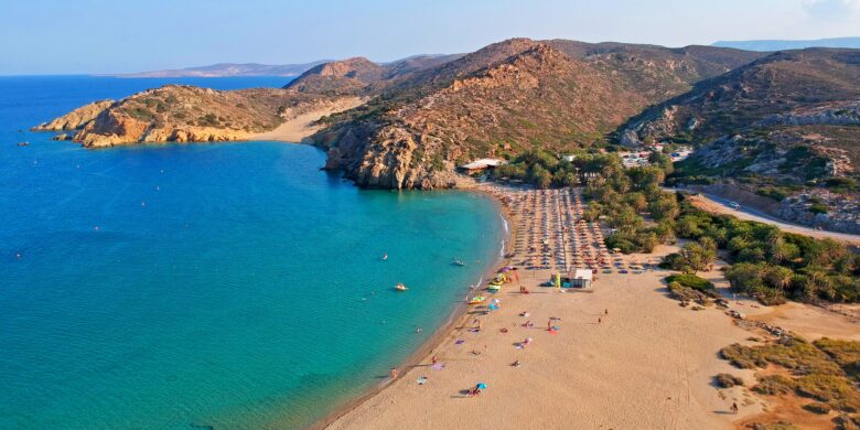 Vai Beach in Crete Greece with palm trees, sandy shore, and clear blue sea.