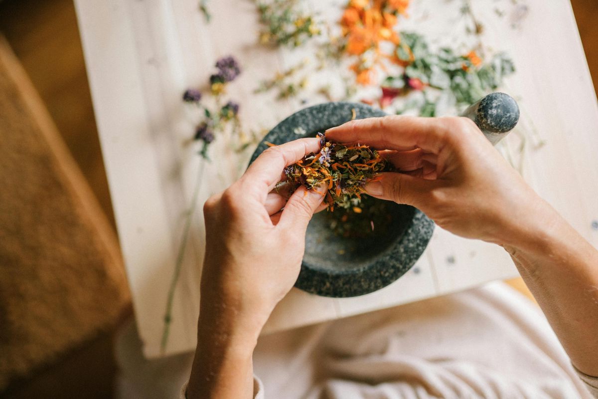 Preparing Cretan herbs for traditional use, highlighting natural farming and local products.