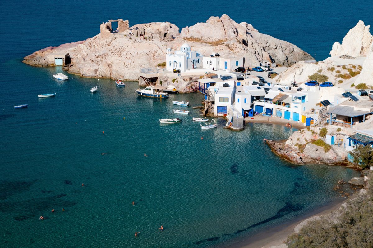 Fishing village with white houses and boats on Milos Island, Greece