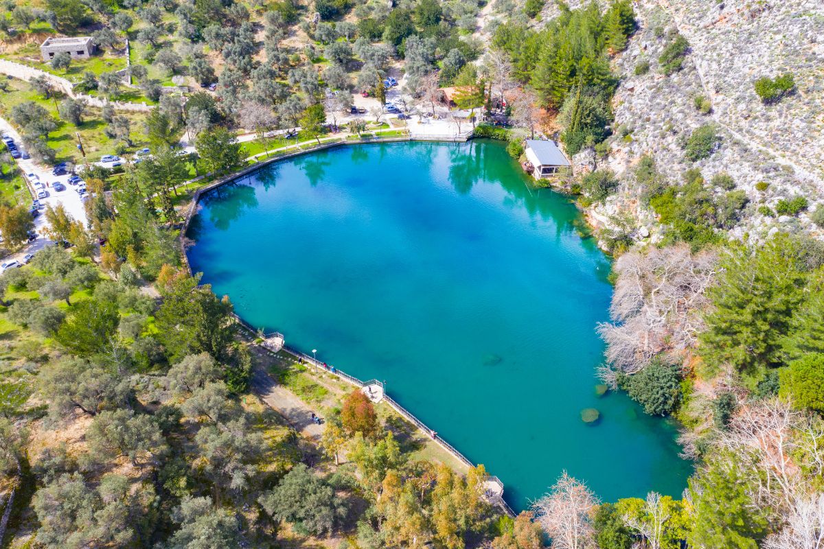 Aerial view of Lake Zaros surrounded by olive groves and mountain scenery in Crete, Greece.