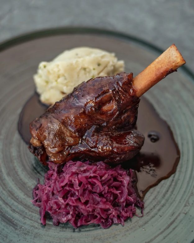 Slow cooked lamb shank with confit garlic flavored mash potato and sautéed red sour-cabbage in apple vinegar at Pallas Chania