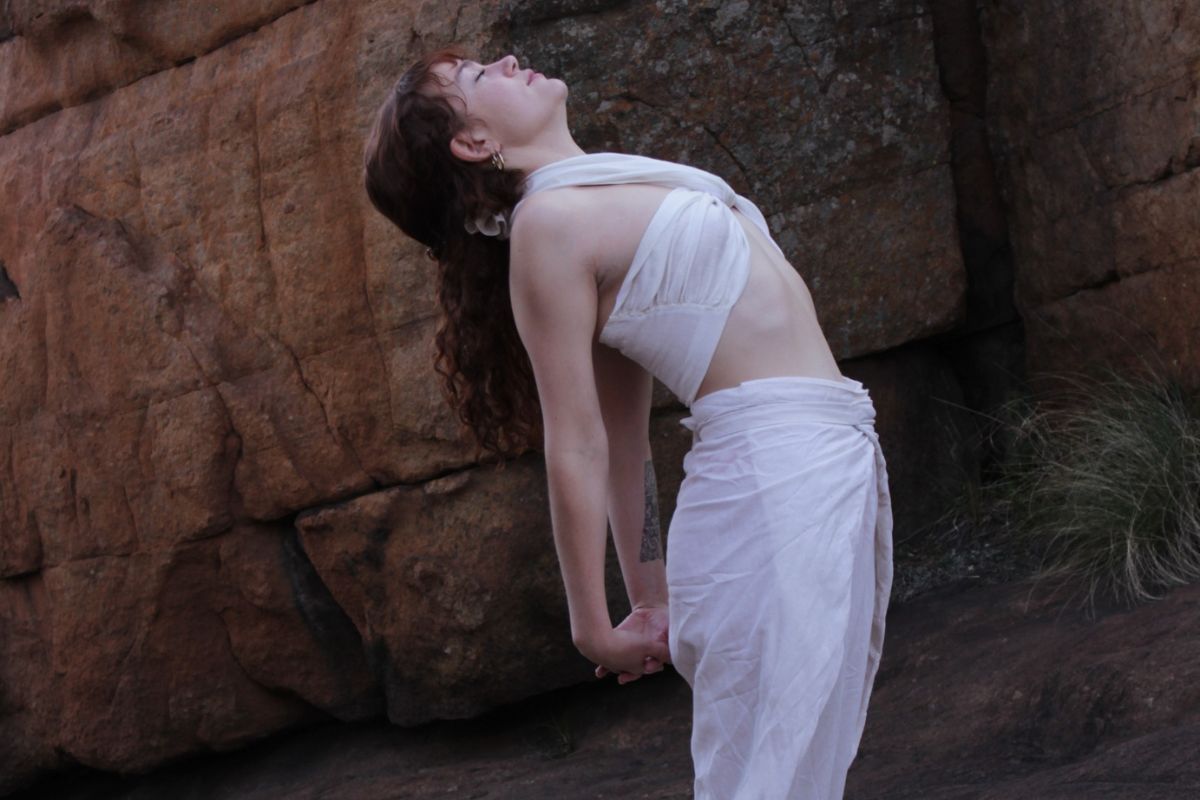 Woman practicing a mindful stretch outdoors, representing yin and yang balance and breath.
