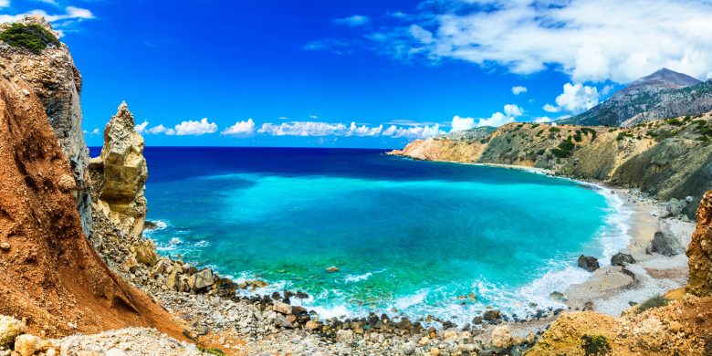 Panoramic view of a coastal landscape with cliffs and a turquoise sea.