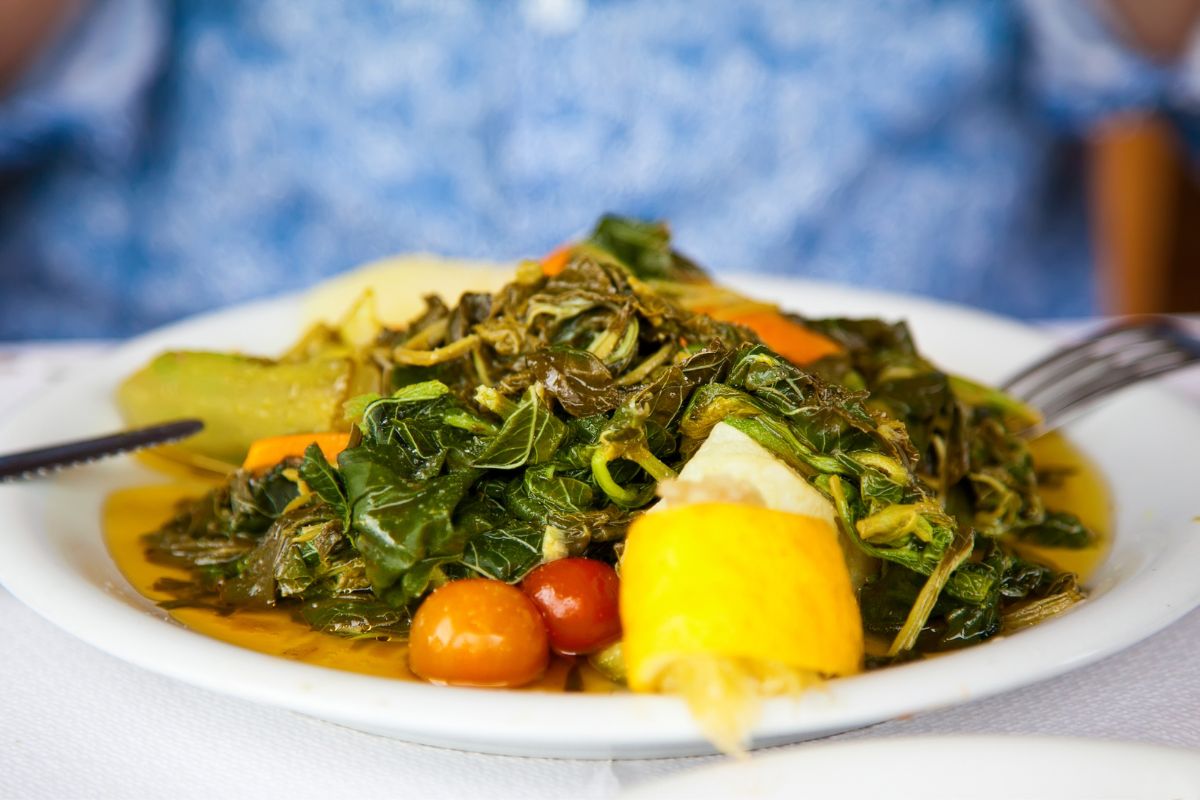 Traditional Cretan food dish of boiled horta greens served with vegetables and lemon, a staple of the Cretan diet.