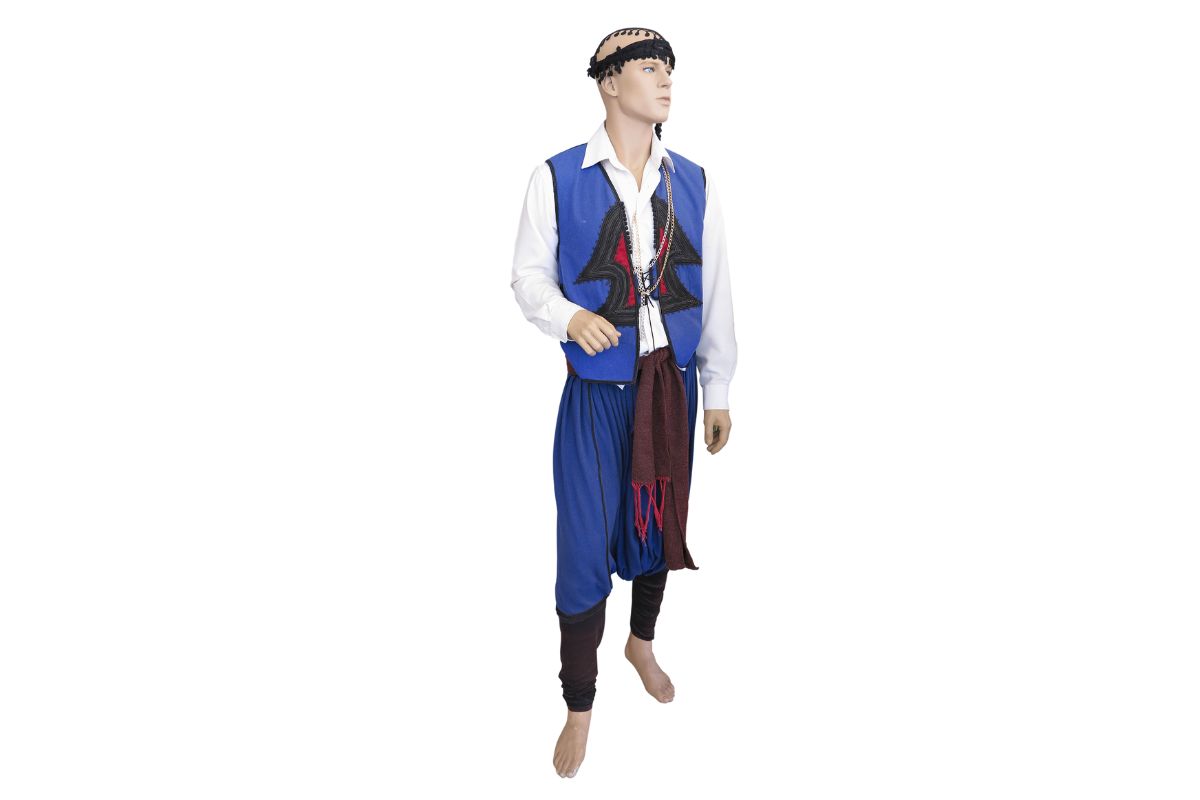 Traditional male Cretan costume displayed on a mannequin with a blue vest, white shirt, and vraka trousers.