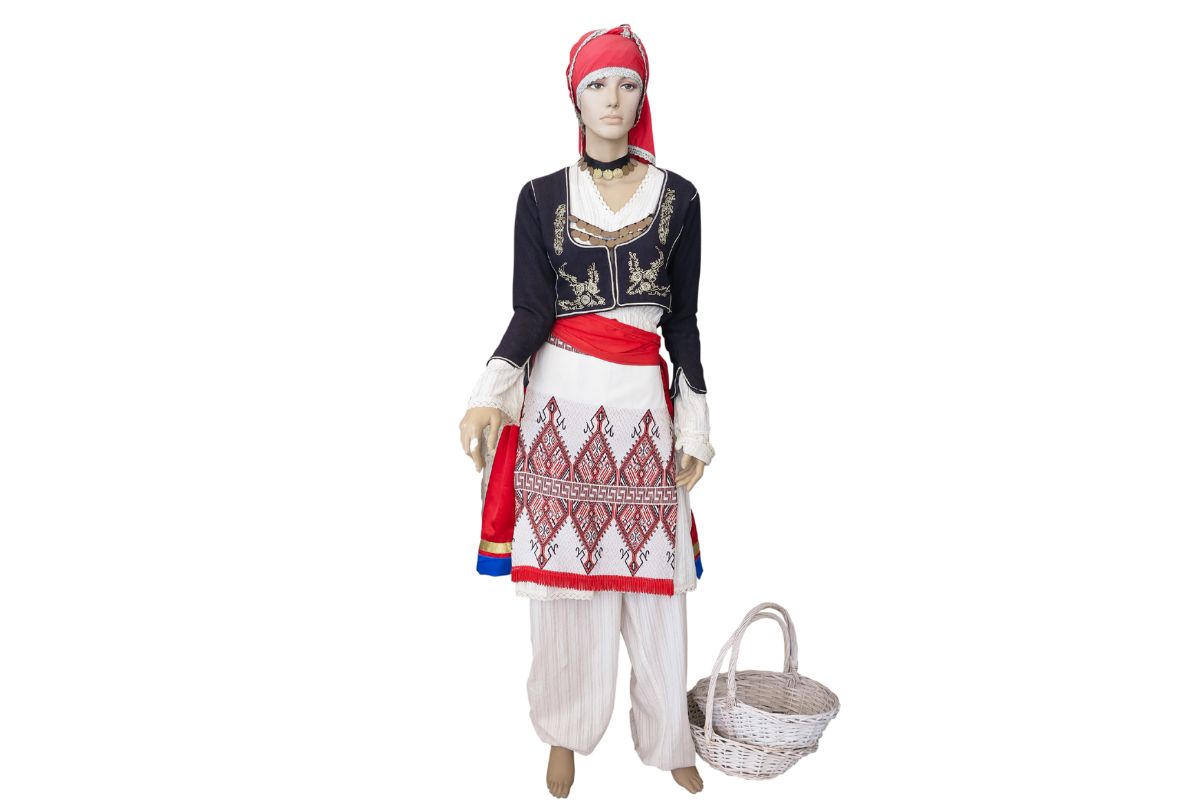 Traditional female Cretan costume displayed on a mannequin with embroidered apron, headscarf, and basket.