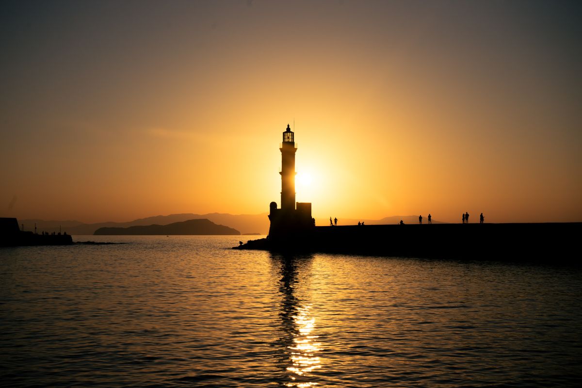 Sunset view of the Chania Lighthouse in Crete, a popular Crete to do activity for evening strolls and scenic photography.