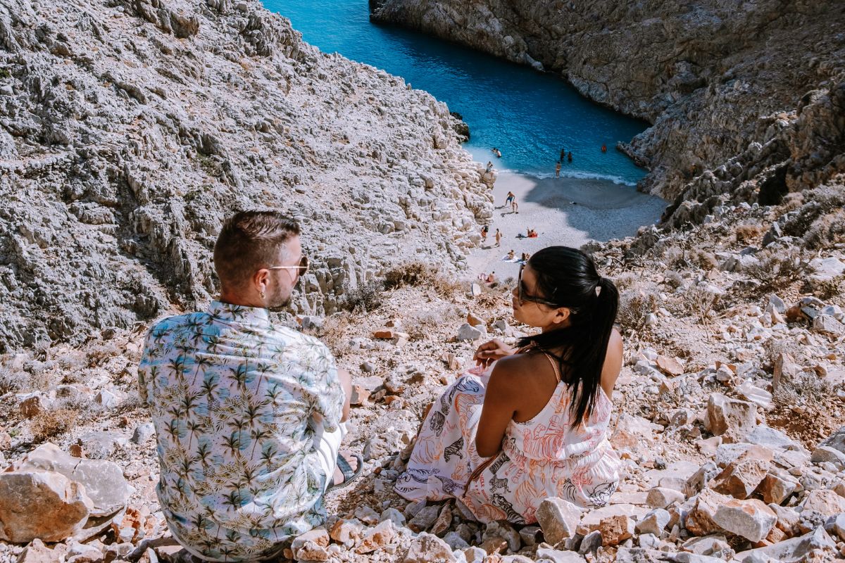Couple overlooking Seitan Limania beach Crete from the rocky path above
