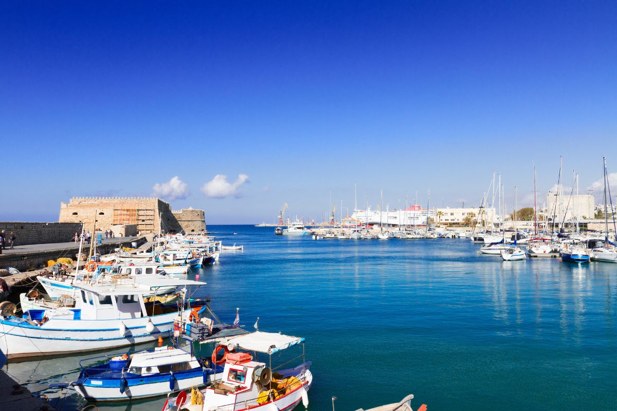 Heraklion port in Crete with fishing boats and ferries.