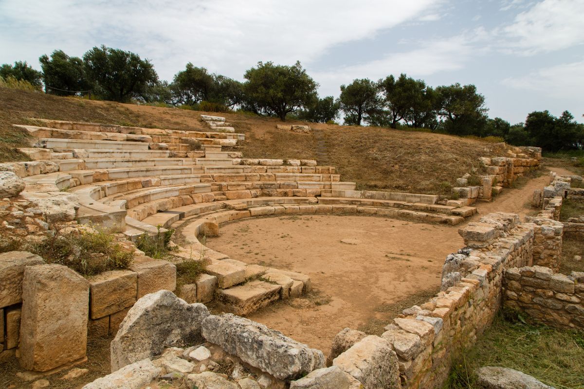 Ancient theater at the archaeological site of Aptera in Crete, Greece, showcasing well-preserved stone seating and historical ruins