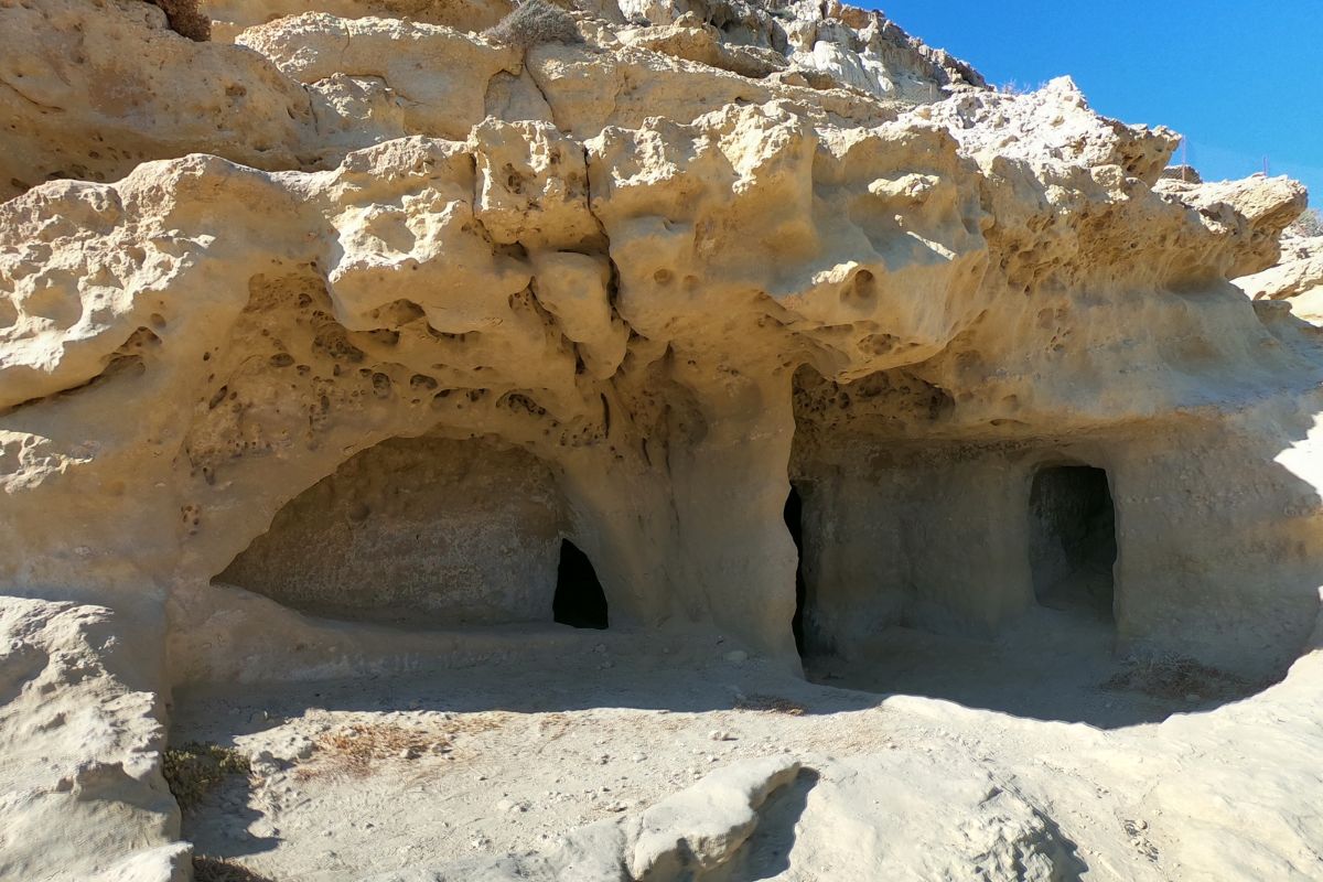 Ancient rock-cut Matala Caves in Crete, Greece, carved into the limestone cliffs near the sea.