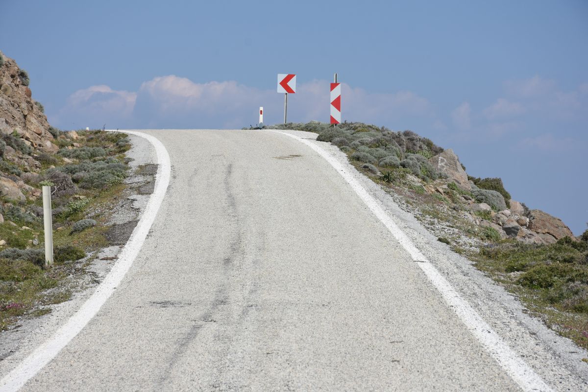 Mountain road with curve signs on the drive to Imbros Gorge in Crete.
