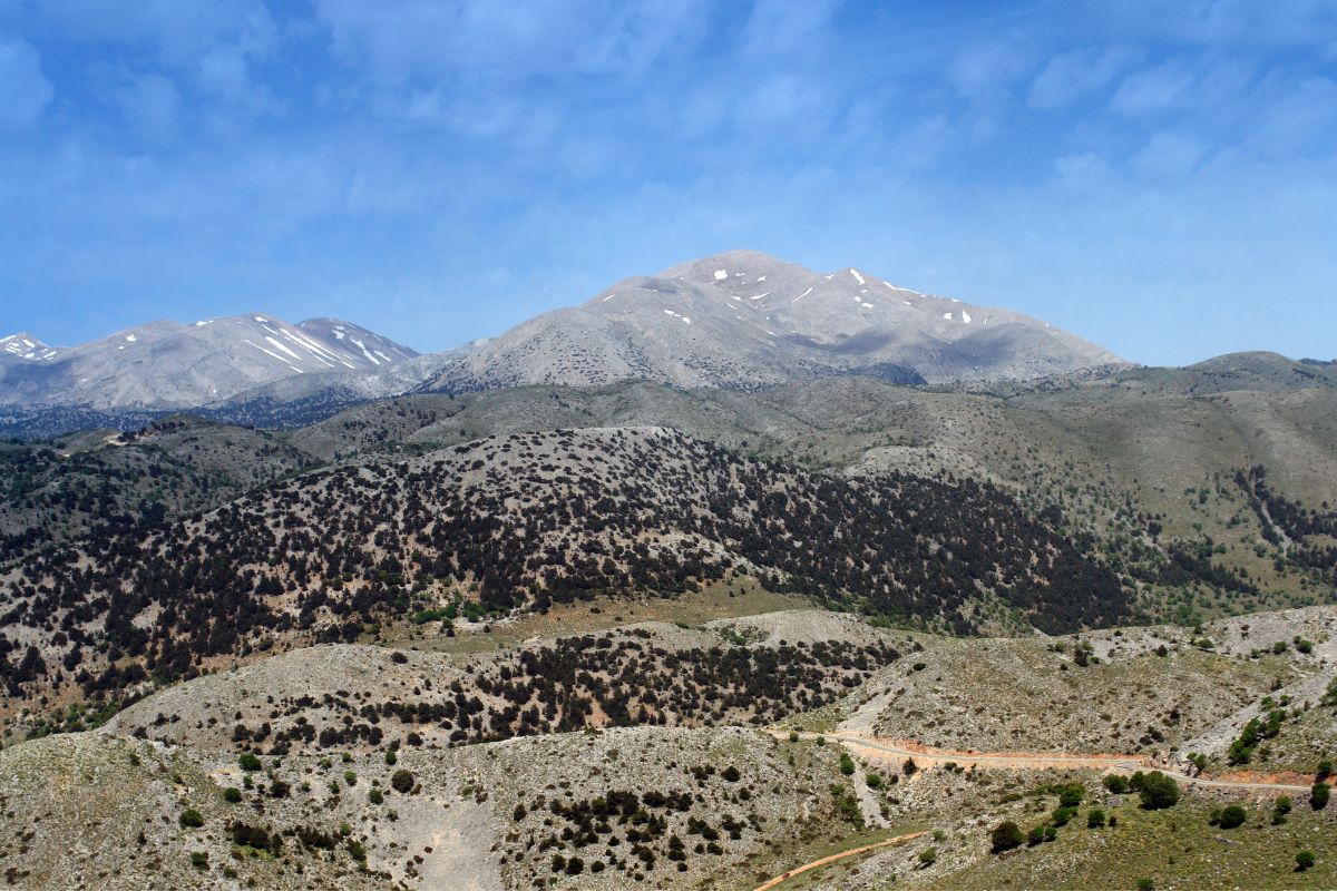 Lefka Ori (Crete White Mountains) landscape with rocky hills and distant peaks under a blue sky.