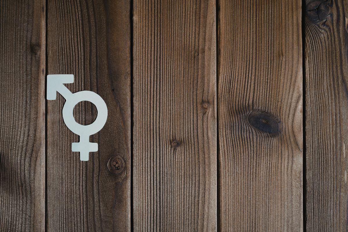 Male and female symbol on a wooden surface, representing divine masculine and feminine energy and gender balance.