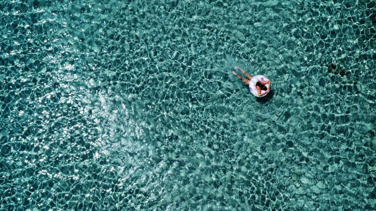 Elafonisi Beach in Crete in June with clear turquoise water and a swimmer floating in the sea.