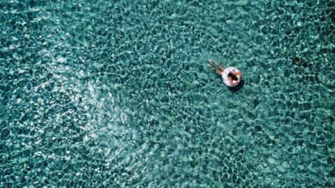 Elafonisi Beach in Crete in June with clear turquoise water and a swimmer floating in the sea.