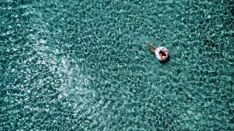Elafonisi Beach in Crete in June with clear turquoise water and a swimmer floating in the sea.