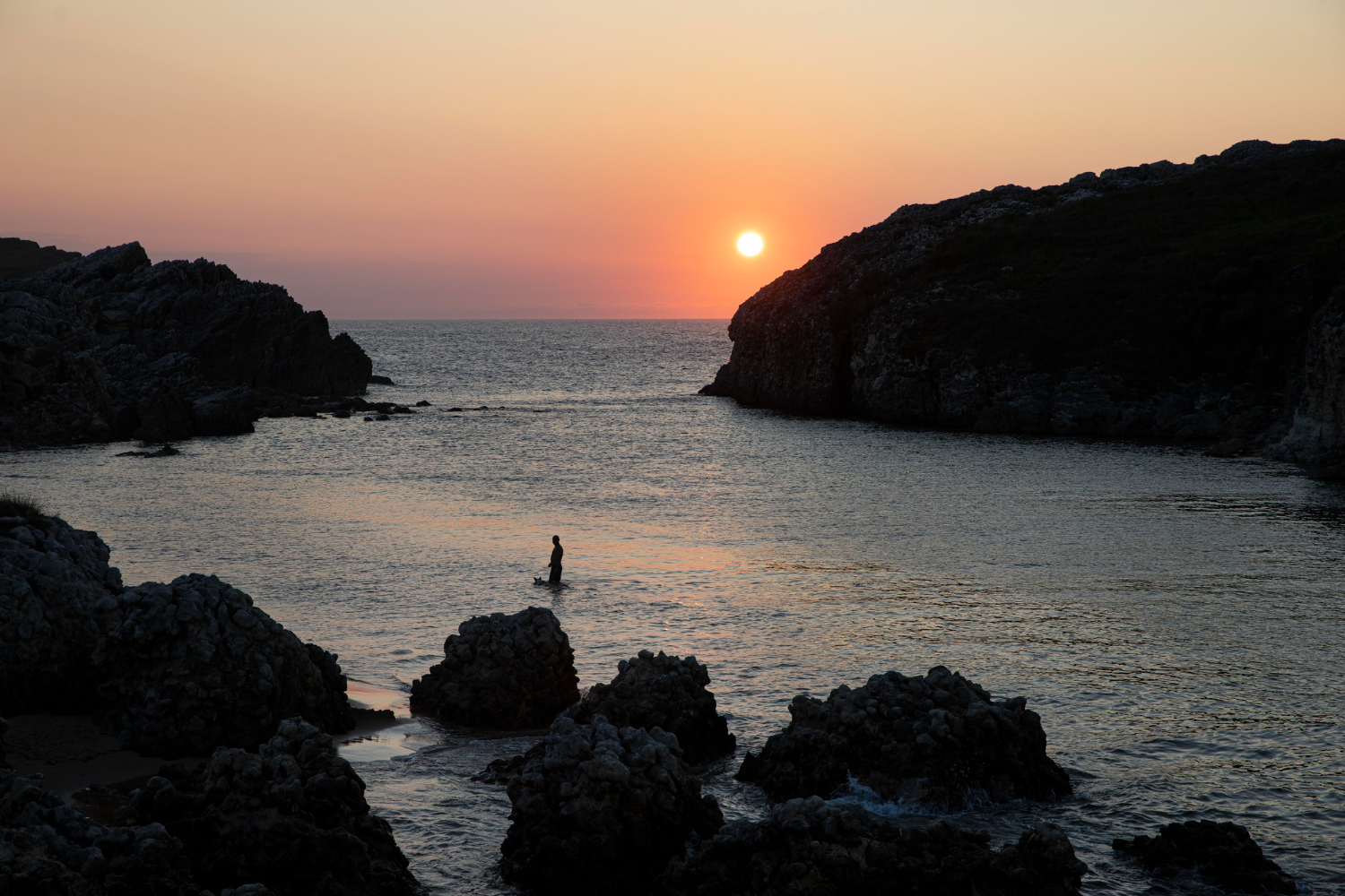 Sunset over a rocky coastal cove in Crete Greece