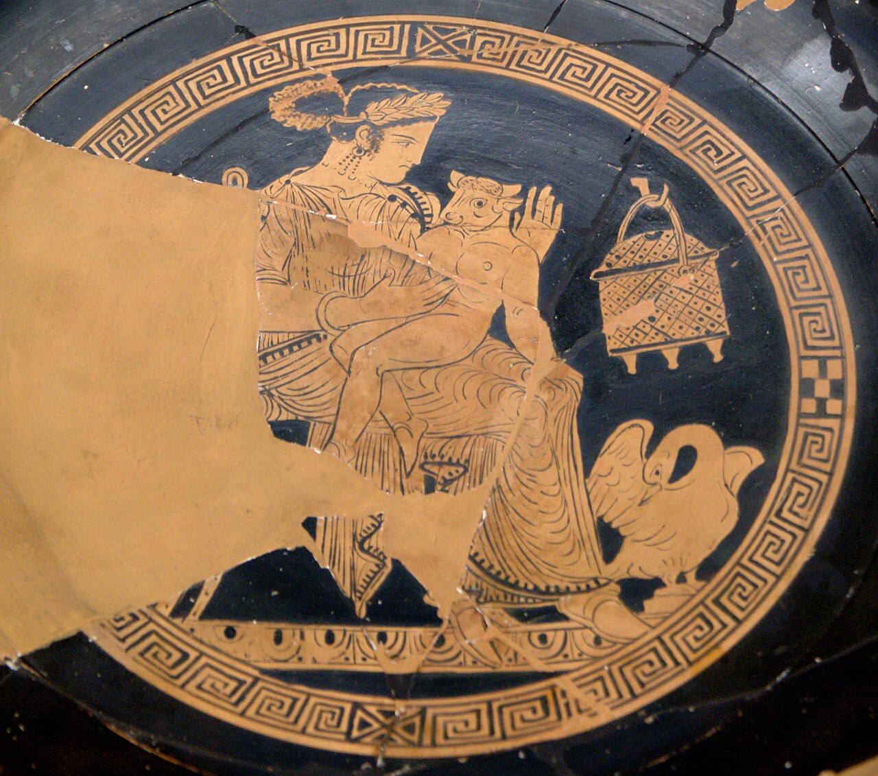 Pasiphae holding the young Minotaur of Crete on an ancient Greek red-figure kylix from the 4th century BCE Copy alt text