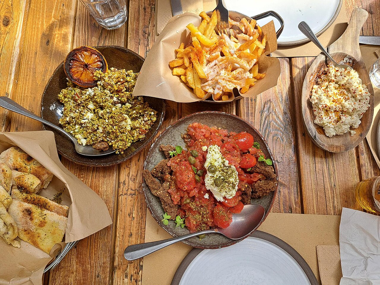 Traditional Greek cuisine featuring Cretan dakos salad, tirosalata, staka potatoes, legumes, and pita bread