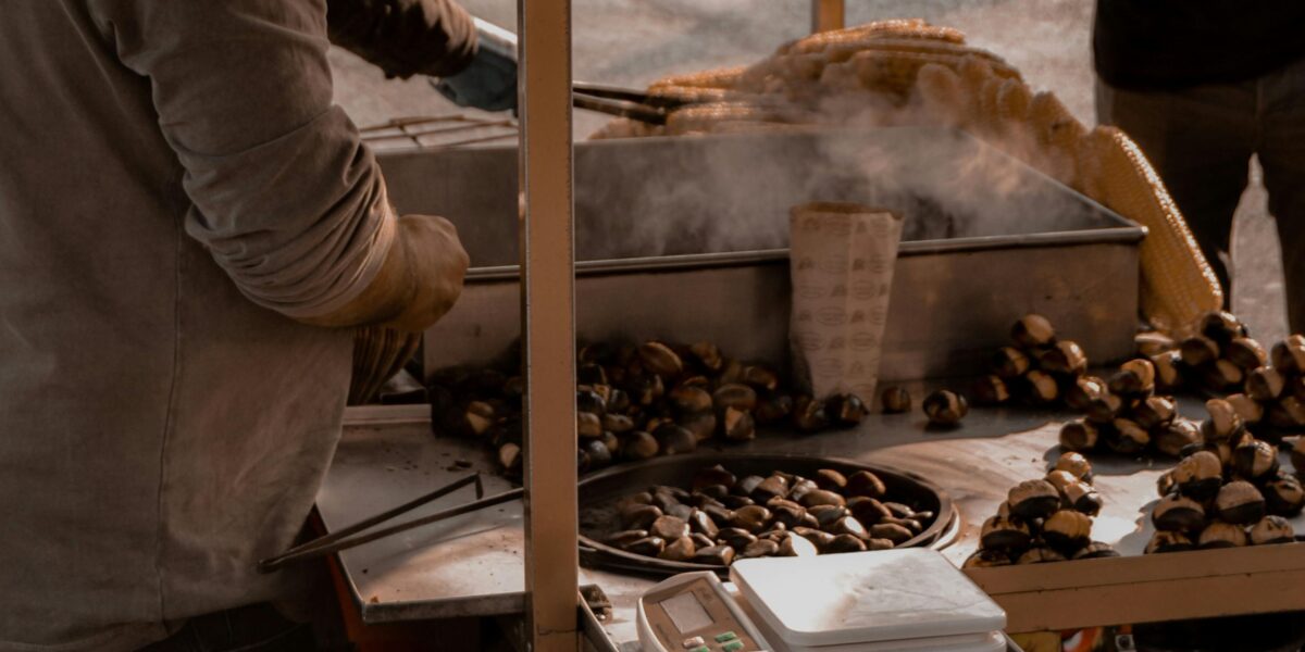 Vendor roasting and serving chestnuts at the Elos Chestnut Festival in Crete.