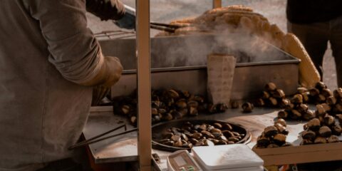 Vendor roasting and serving chestnuts at the Elos Chestnut Festival in Crete.